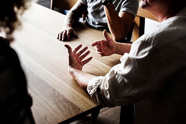 Diskutierende Menschen am Tisch