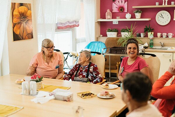 Lachende Seniorinnen in einer Wohngruppe