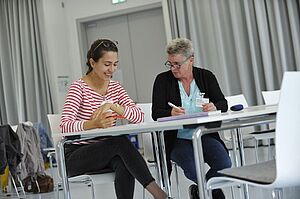 Zwei Frauen unterhalten sich im Seminarraum